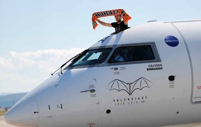Parejo muestra una bufanda del Valencia desde una escotilla del avión